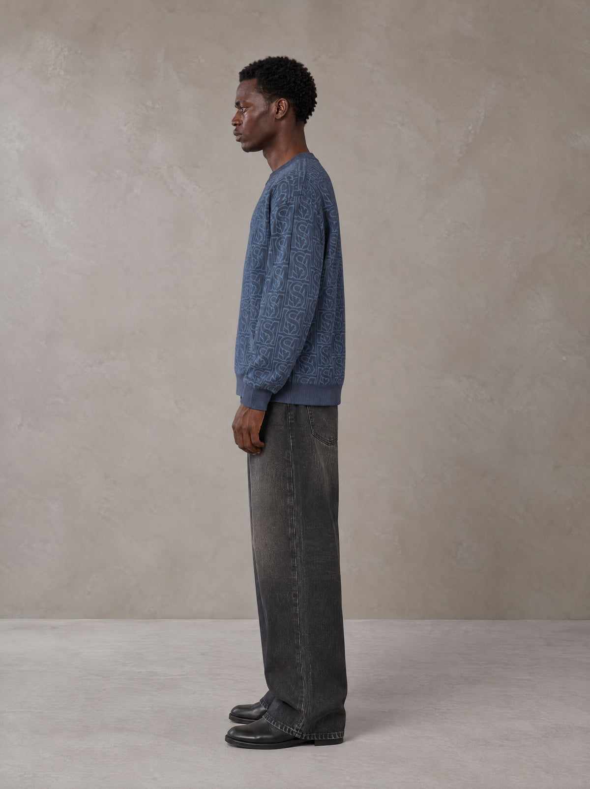 Model wearing the SM Jacquard Knitted Sweatshirt in Chambray, side profile.