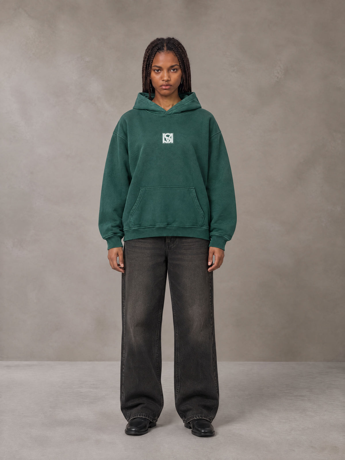 Model wearing the SM Monkey Wash Hoodie in Alpine Green, front view.