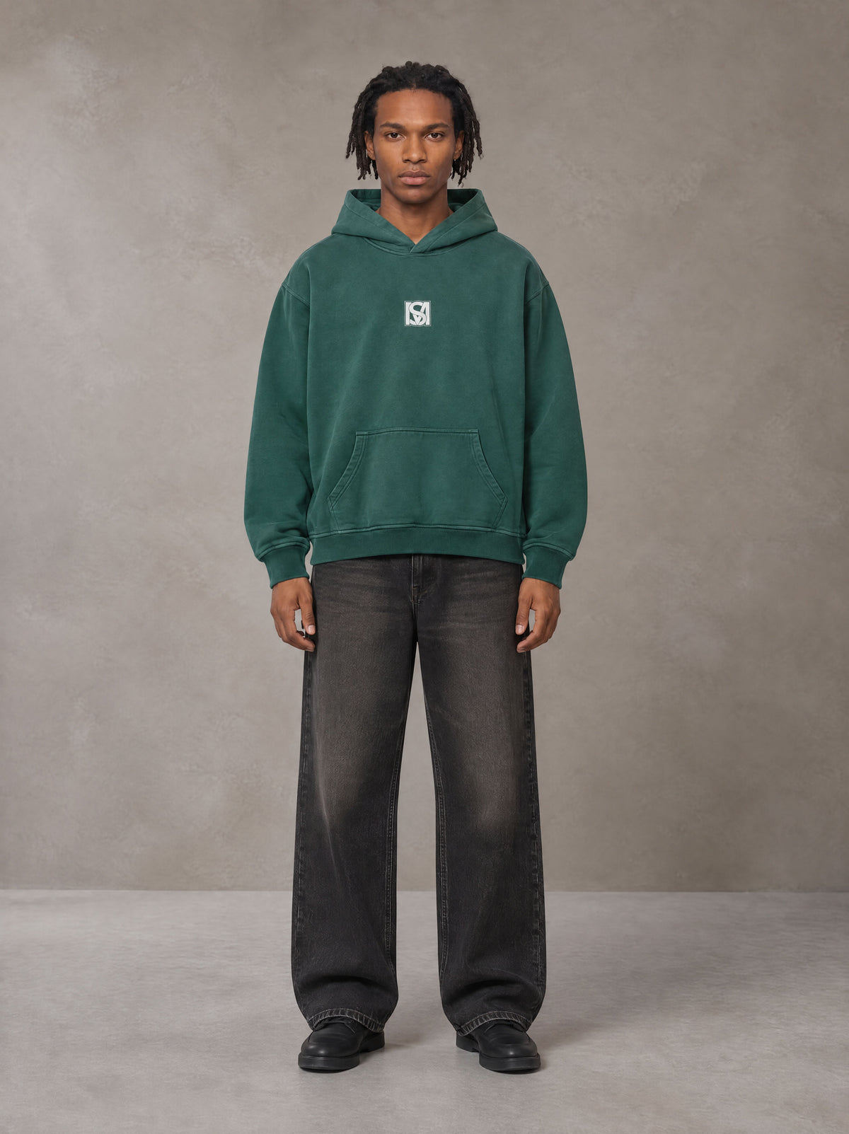 Model wearing the SM Monkey Wash Hoodie in Alpine Green, front view.