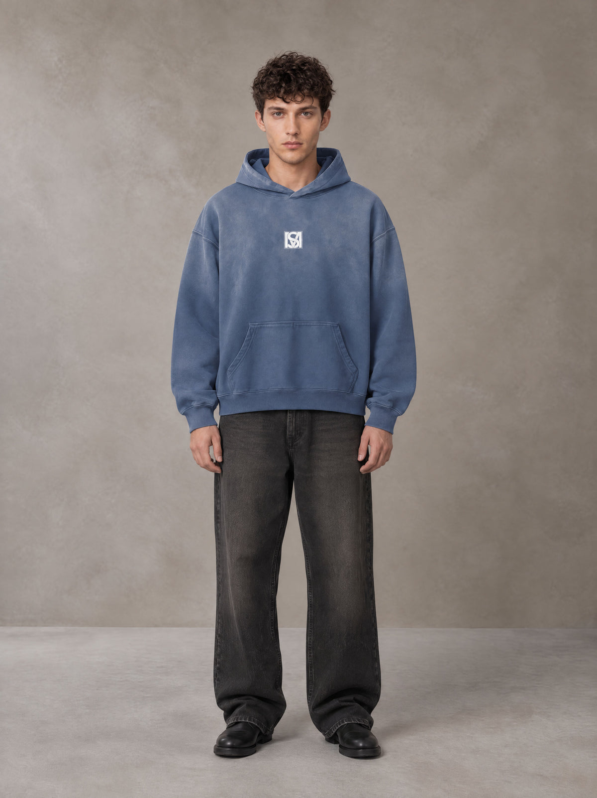 Model wearing the SM Monkey Wash Hoodie in Chambray, front view.