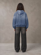 Model wearing the SM Monkey Wash Hoodie in Chambray, rear view.