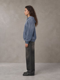 Model wearing the SM Monkey Wash Hoodie in Chambray, side profile.