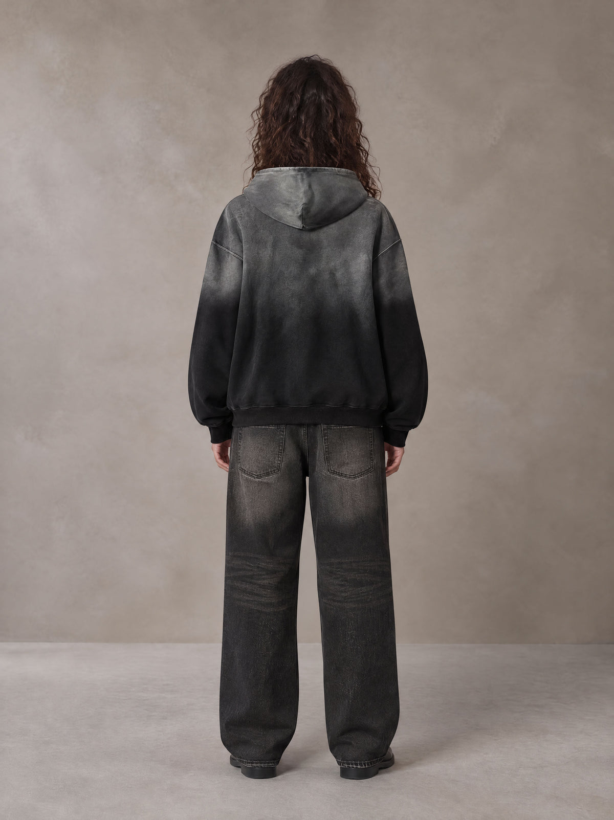 Model wearing the SM Monkey Wash Hoodie in Midnight Black, rear view.