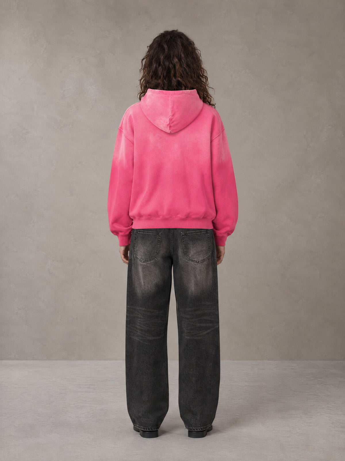 Model wearing the SM Monkey Wash Hoodie in Vivid Pink, rear view.