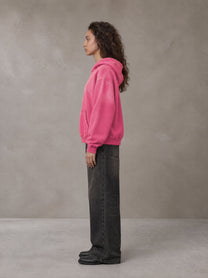 Model wearing the SM Monkey Wash Hoodie in Vivid Pink, side profile.