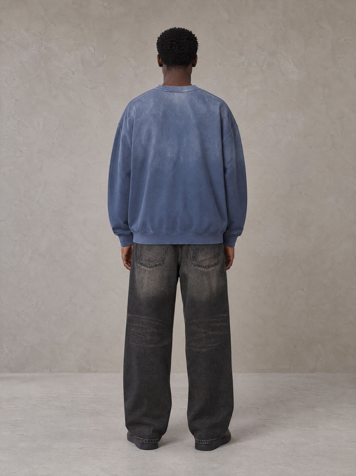 Model wearing the SM Monkey Wash Sweatshirt in Chambray, rear view.