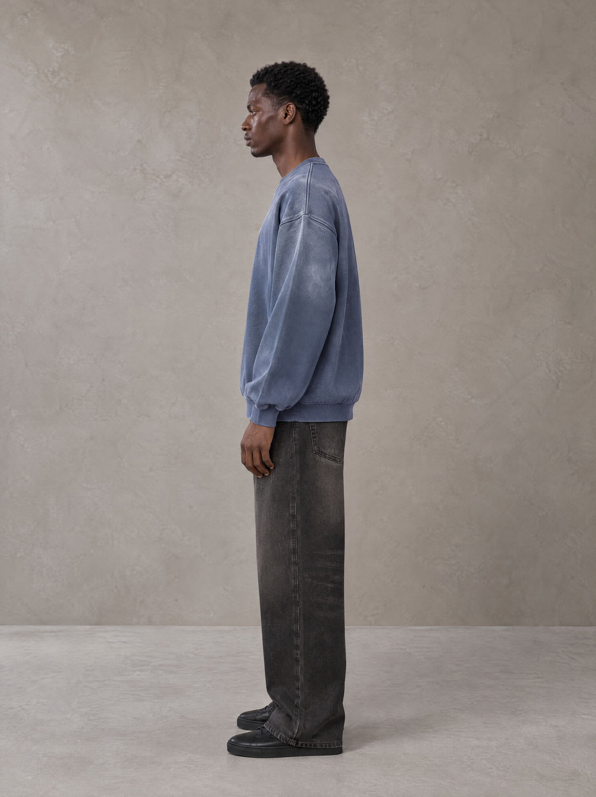 Model wearing the SM Monkey Wash Sweatshirt in Chambray, side profile.