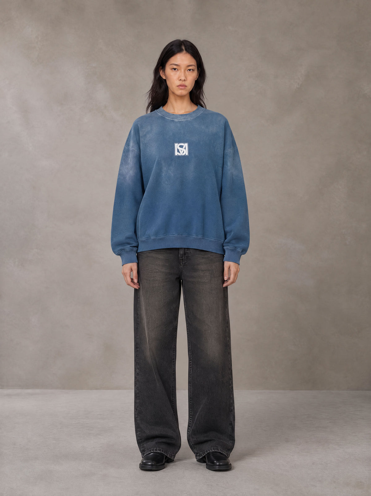 Model wearing the SM Monkey Wash Sweatshirt in Deep Denim, front view.