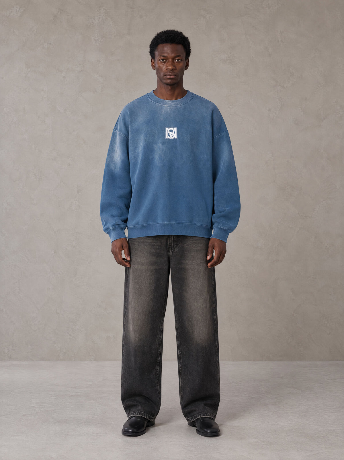 Model wearing the SM Monkey Wash Sweatshirt in Deep Denim, front view.
