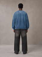 Model wearing the SM Monkey Wash Sweatshirt in Deep Denim, rear view.