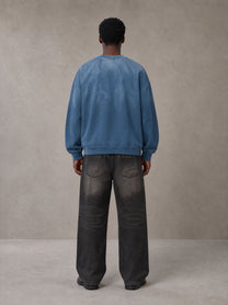 Model wearing the SM Monkey Wash Sweatshirt in Deep Denim, rear view.