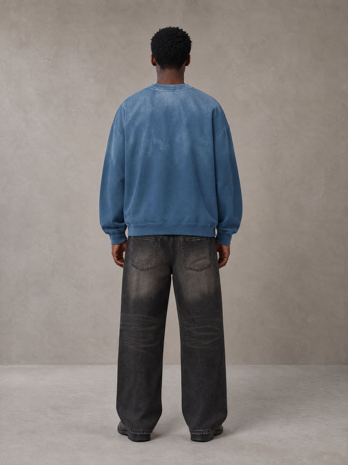 Model wearing the SM Monkey Wash Sweatshirt in Deep Denim, rear view.