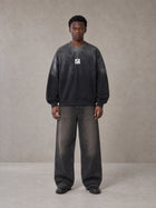 Model wearing the SM Monkey Wash Sweatshirt in Midnight Black, front view.
