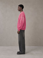 Model wearing the SM Monkey Wash Sweatshirt in Vivid Pink, side profile.