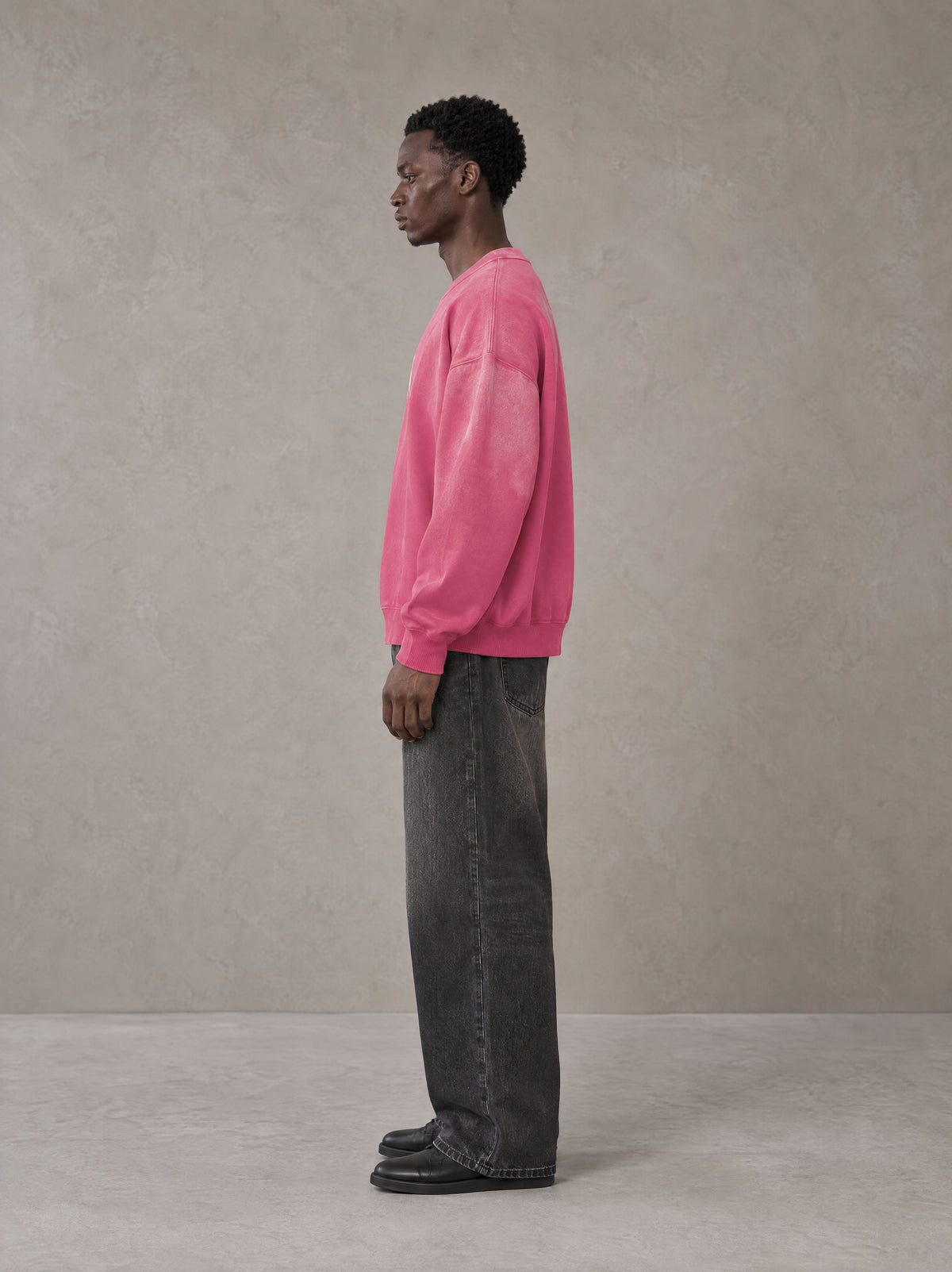 Model wearing the SM Monkey Wash Sweatshirt in Vivid Pink, side profile.