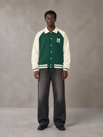 Model wearing the SM Varsity Baseball Jacket in Eden Green, front view.