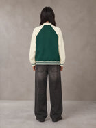 Model wearing the SM Varsity Baseball Jacket in Eden Green, rear view.