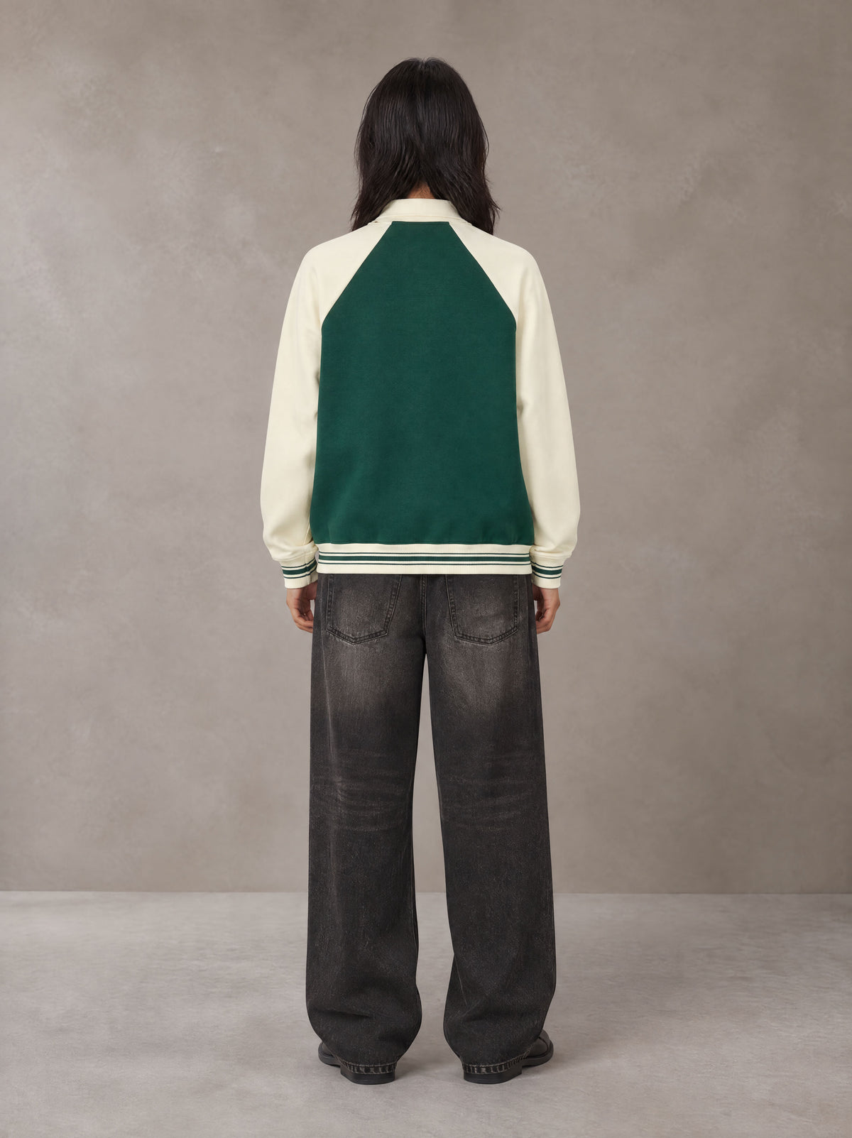 Model wearing the SM Varsity Baseball Jacket in Eden Green, rear view.