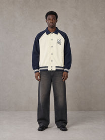 Model wearing the SM Varsity Baseball Jacket in Oxford Navy, front view.