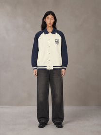 Model wearing the SM Varsity Baseball Jacket in Oxford Navy, front view.