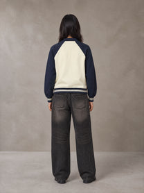 Model wearing the SM Varsity Baseball Jacket in Oxford Navy, rear view.
