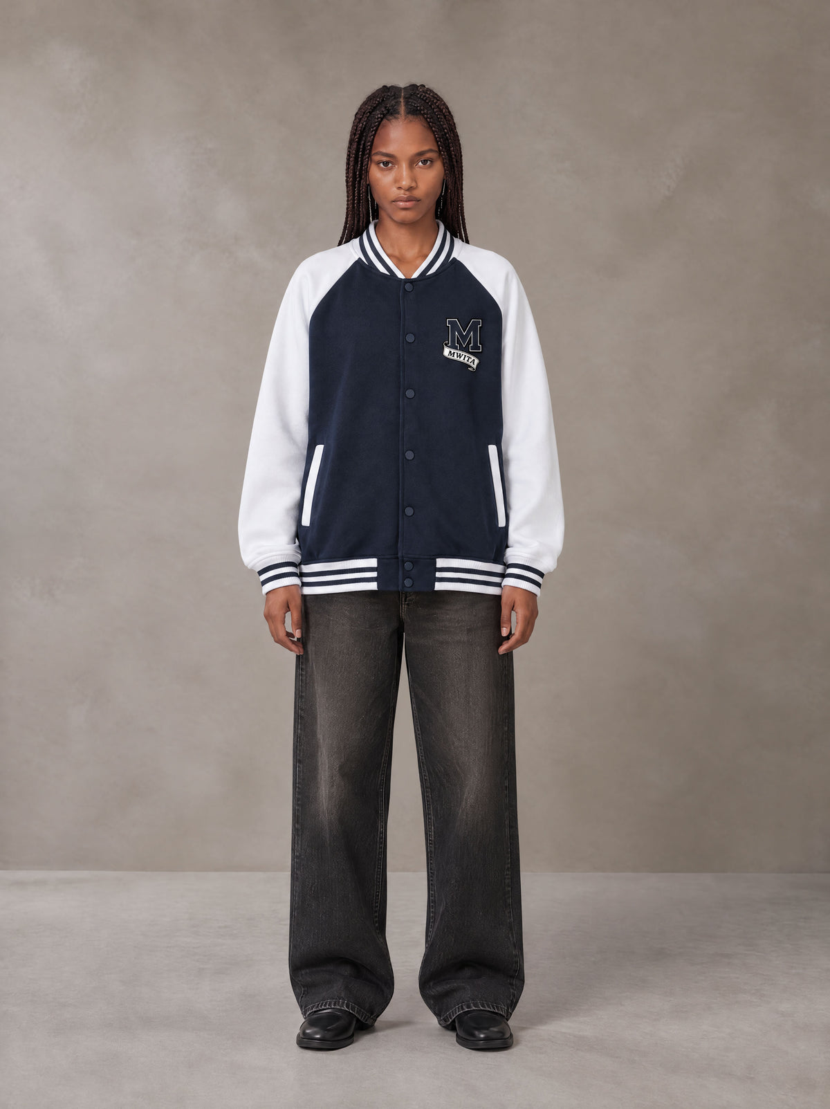 Model wearing the SM Varsity Jacket in Oxford Navy, front view.