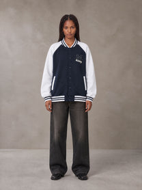 Model wearing the SM Varsity Jacket in Oxford Navy, front view.