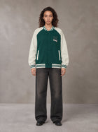 Model wearing the SM Varsity Jacket in Alpine Green, front view.