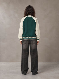 Model wearing the SM Varsity Jacket in Alpine Green, rear view.