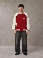 Model wearing the SM Varsity Jacket in Carmine, front view.