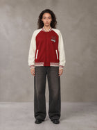 Model wearing the SM Varsity Jacket in Carmine, front view.