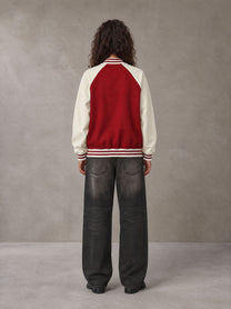 Model wearing the SM Varsity Jacket in Carmine, rear view.