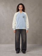 Model wearing the SM Varsity Jacket in Powder Blue, front view.