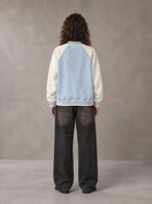 Model wearing the SM Varsity Jacket in Powder Blue, rear view.