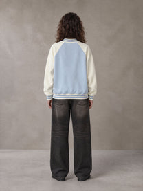 Model wearing the SM Varsity Jacket in Powder Blue, rear view.