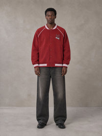 Model wearing the SM Varsity Jacket in Carmine, front view.