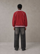 Model wearing the SM Varsity Jacket in Carmine, rear view.