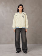Model wearing the SM Varsity Jacket in Classic Cream, front view.