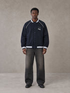 Model wearing the SM Varsity Jacket in Oxford Navy, front view.