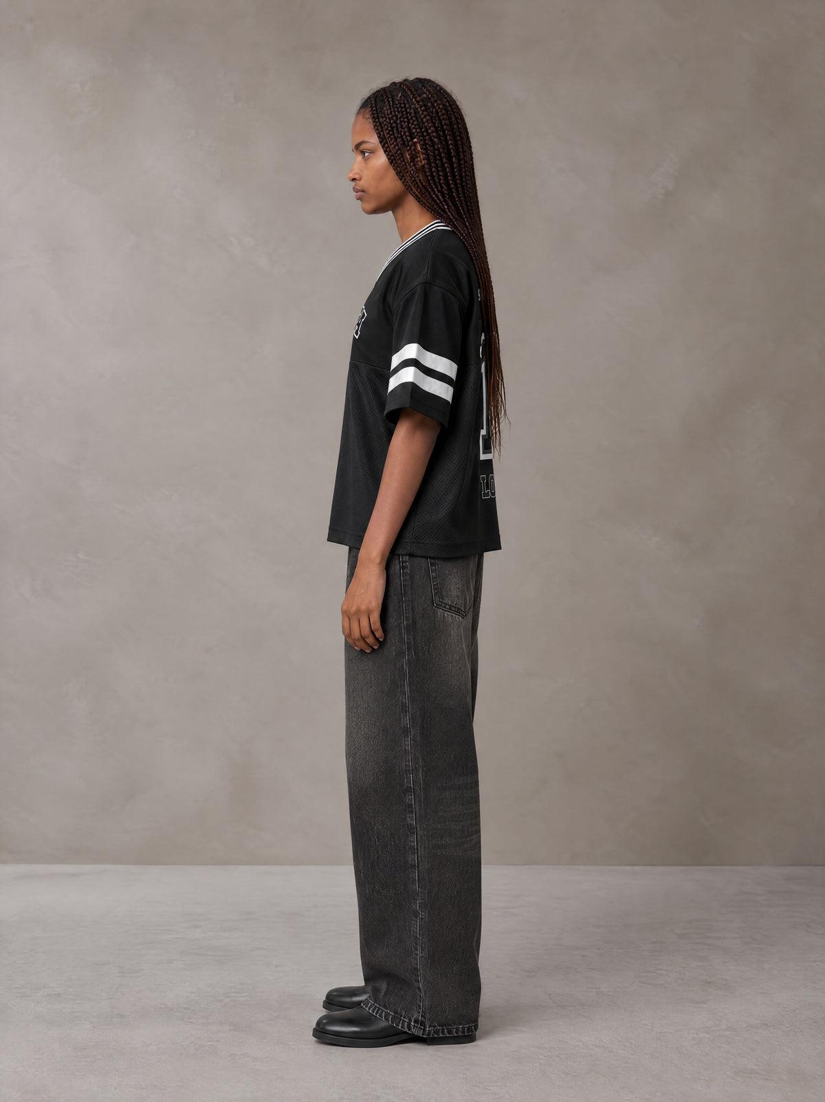 Model wearing the SM Varsity Spirit T-shirt in Midnight Black, side profile.