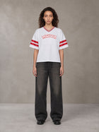 Model wearing the SM Varsity Spirit T-shirt in Lucent White, front view.