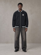 Model wearing the SM Varsity Zip Jacket in Oxford Navy, front view.