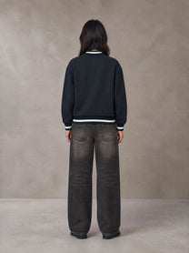 Model wearing the SM Varsity Zip Jacket in Oxford Navy, rear view.