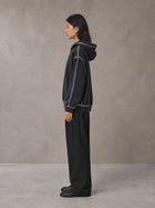 Model wearing the SM Pleated Trousers in Midnight Black, side profile.