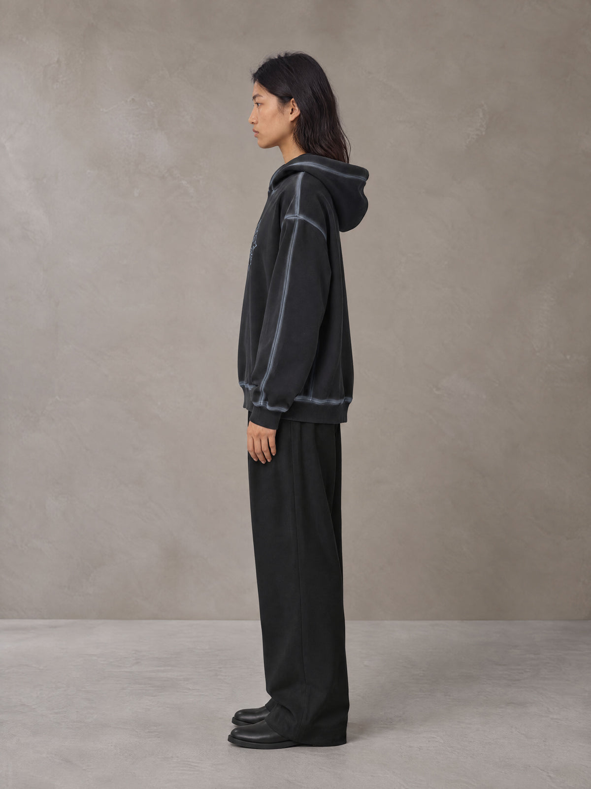 Model wearing the SM Pleated Trousers in Midnight Black, side profile.