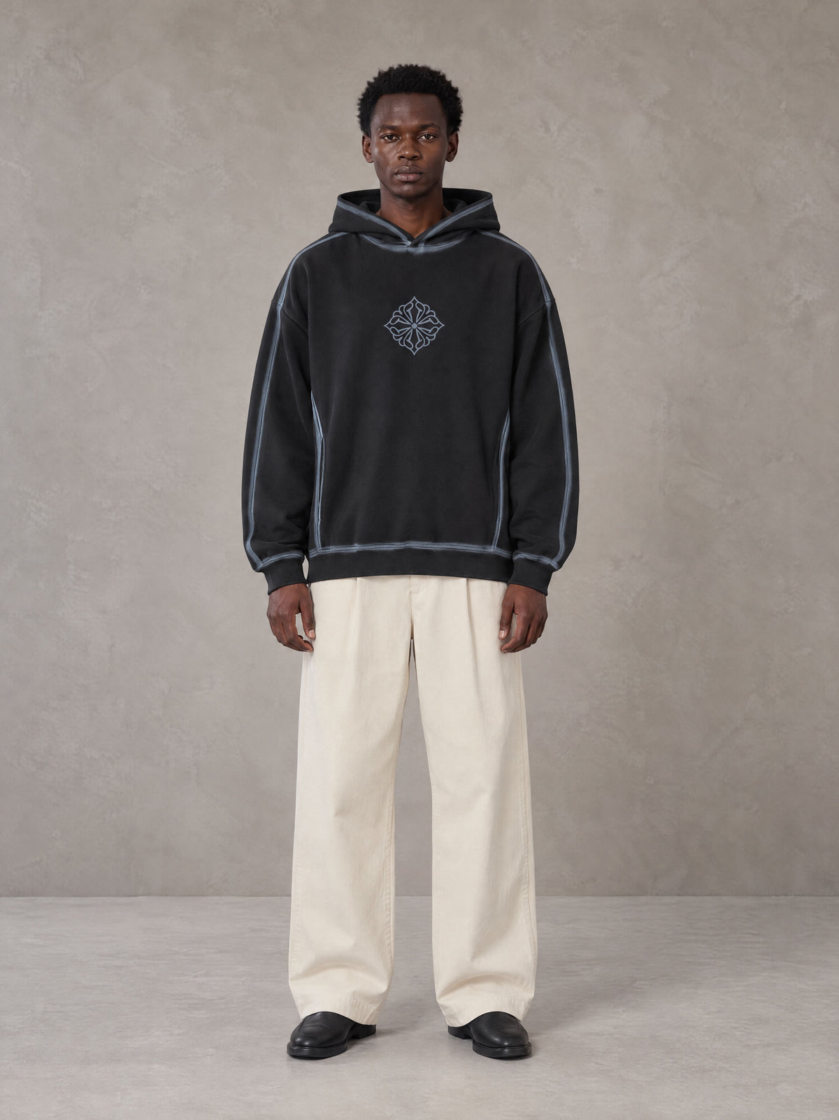 Model wearing the SM Pleated Trousers in Soft Beige, front view.