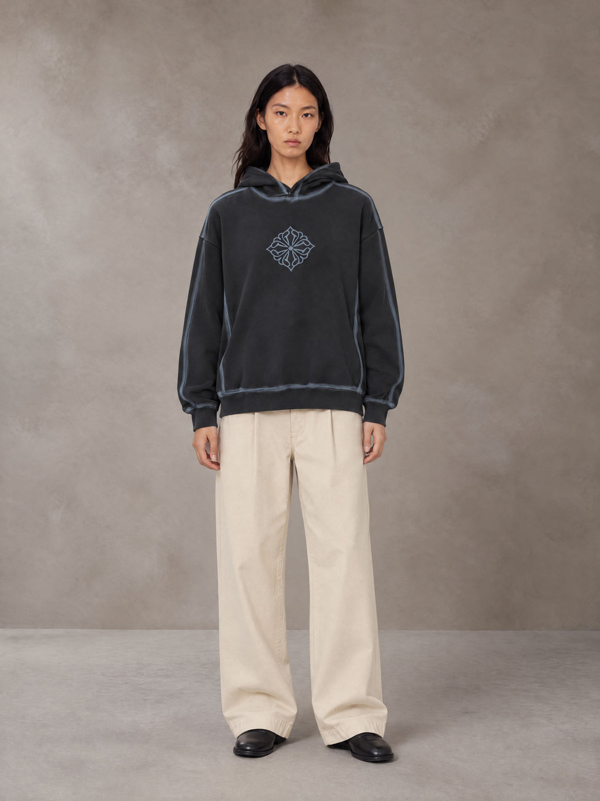 Model wearing the SM Pleated Trousers in Soft Beige, front view.