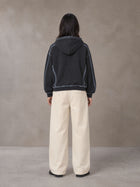Model wearing the SM Pleated Trousers in Soft Beige, rear view.