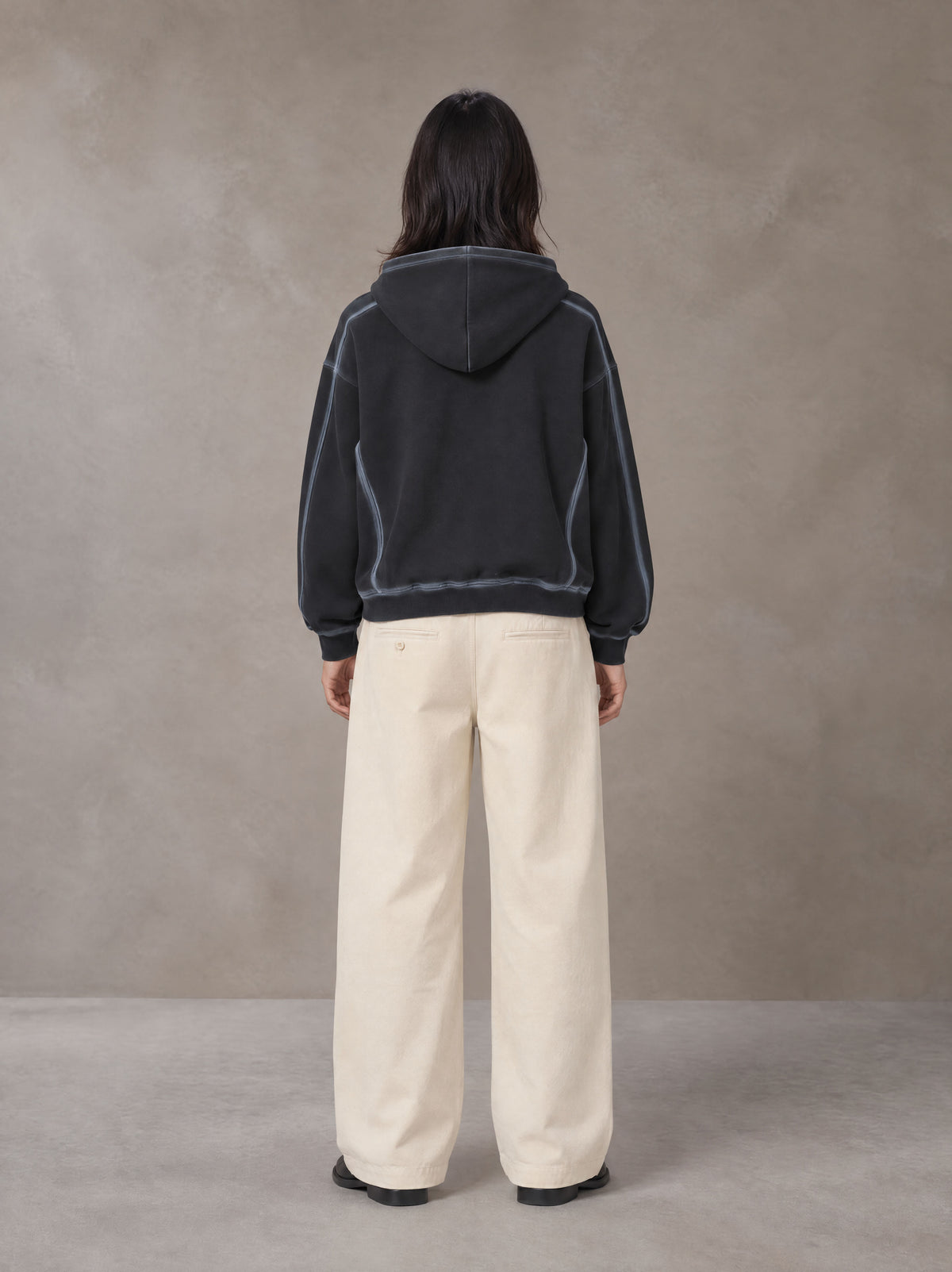 Model wearing the SM Pleated Trousers in Soft Beige, rear view.