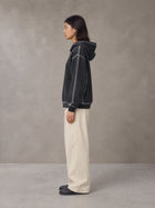 Model wearing the SM Pleated Trousers in Soft Beige, side profile.
